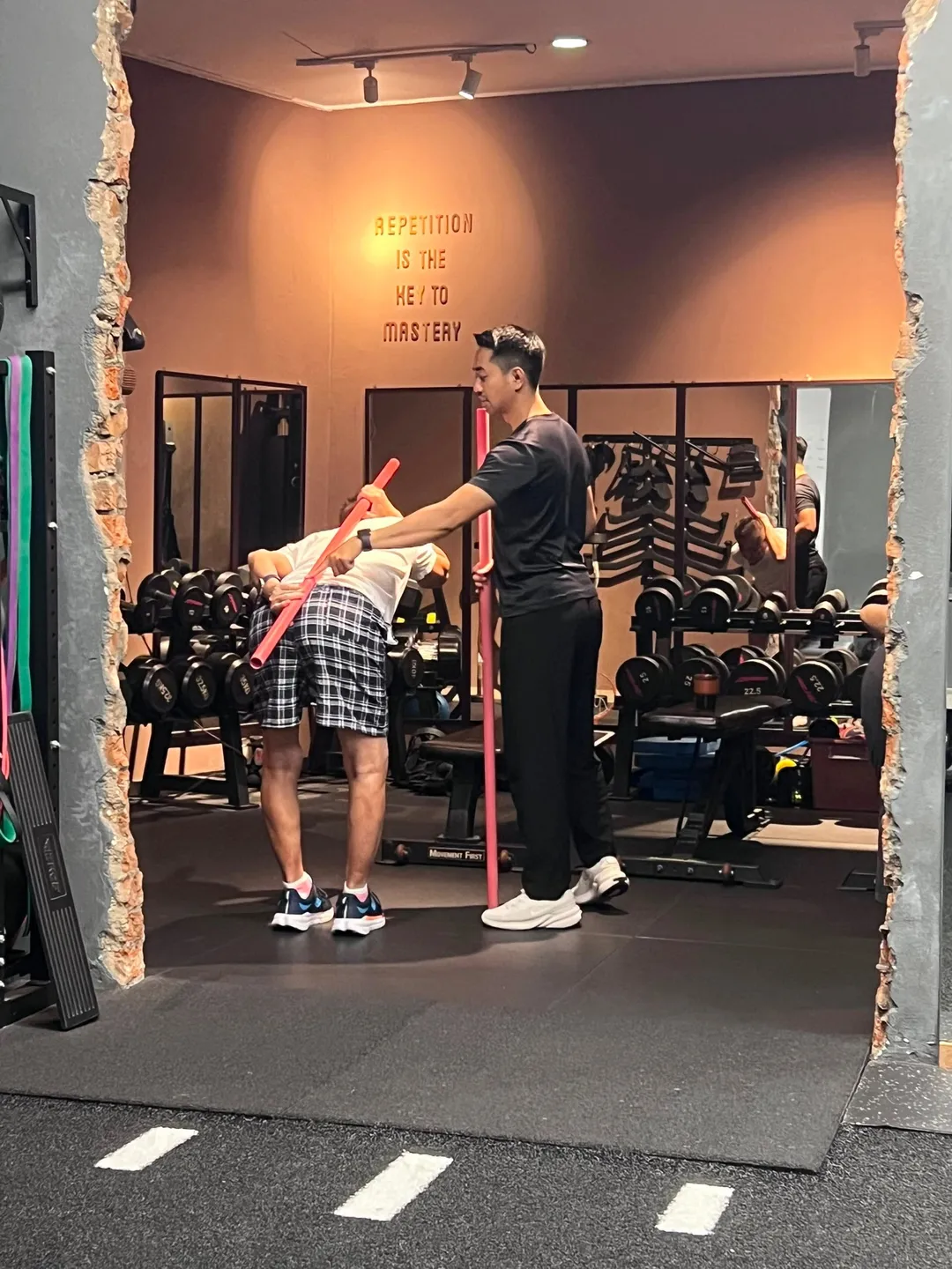 A coach supporting an older adult during a mobility exercise
