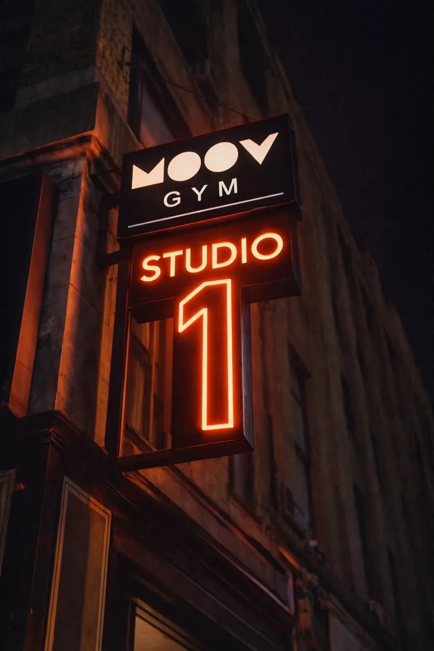 Moov Gym’s illuminated Studio 1 sign on the outside of the building at night